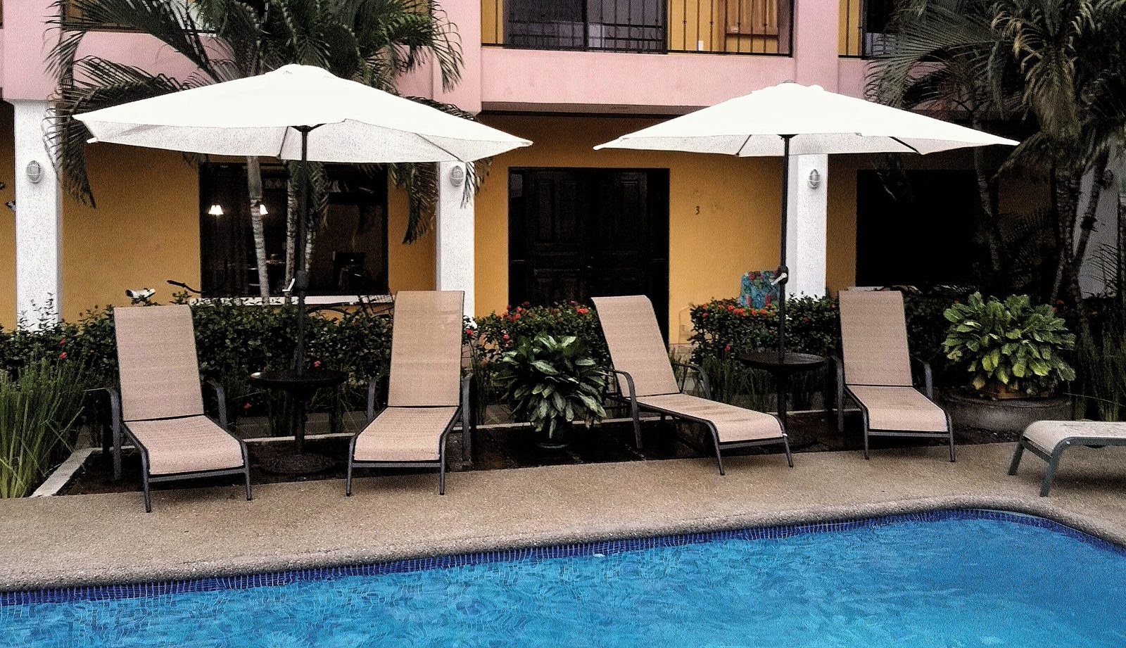 Terraza de piscina con camastros y piso de baldosa Madera Grande