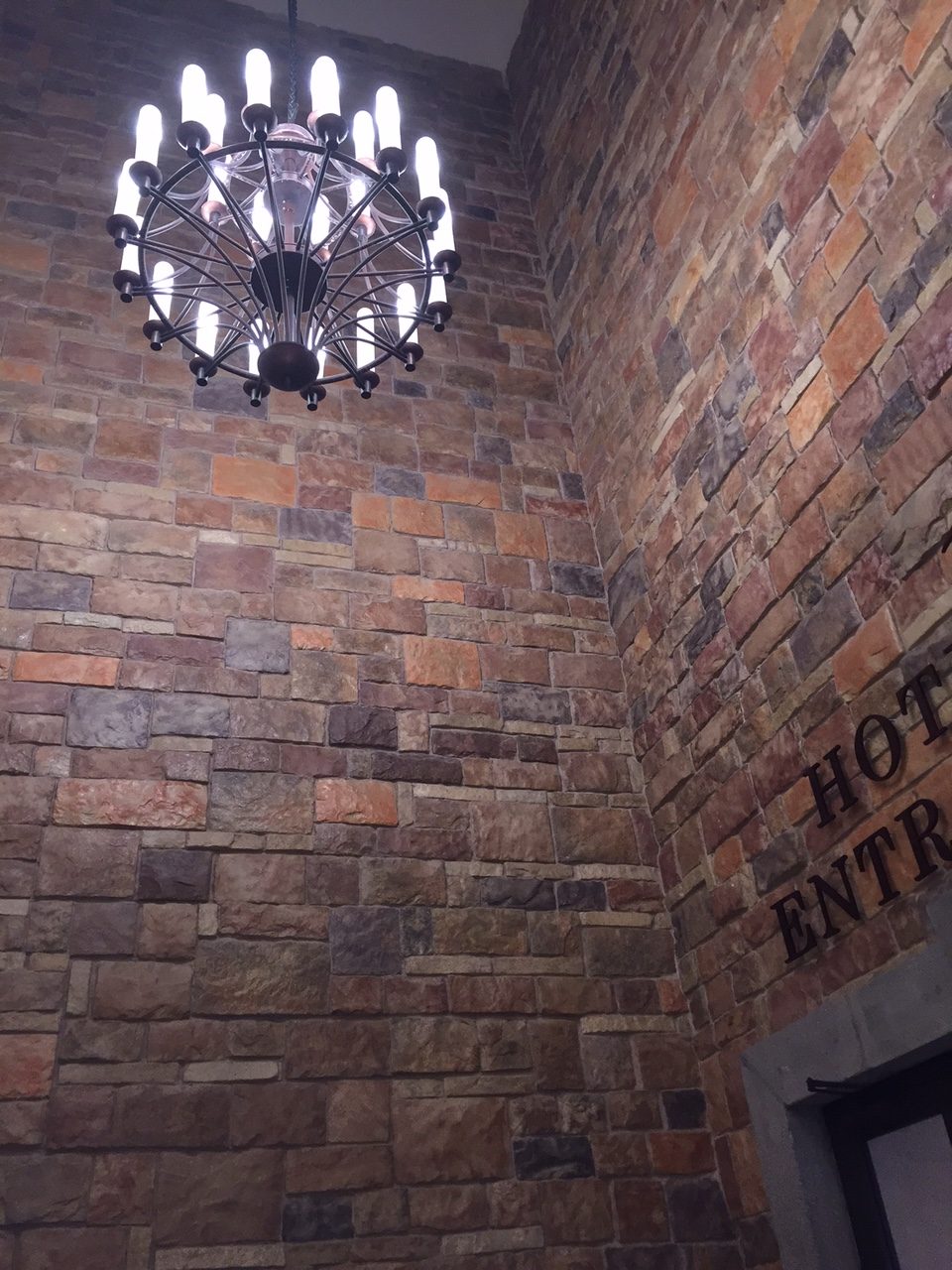 Corredor de hotel con muro y techo revestidos en piedra Hackett Crocs